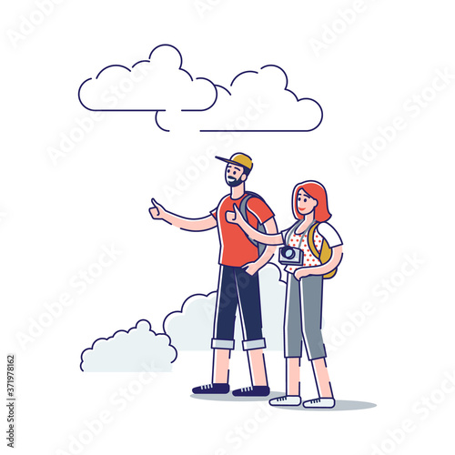 Young couple with backpacks and camera stand on road and hitchhiking. Couple of backpackers travel