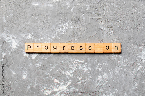 progression word written on wood block. progression text on cement table for your desing, concept