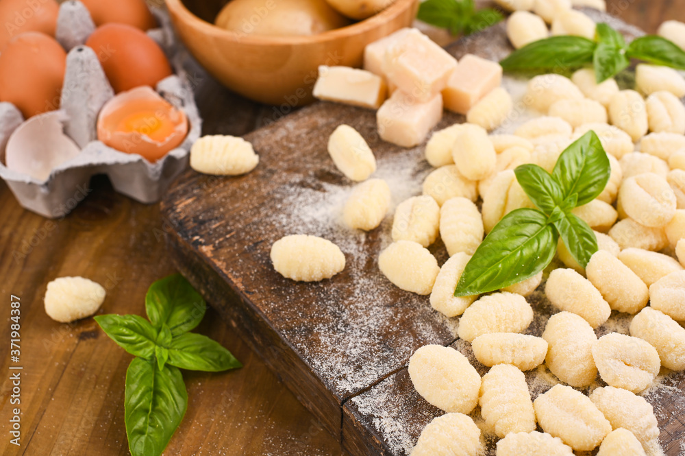 Gnocchi with potatoes. Traditional italian food from Rome, Sardinia, south of italy. Homemade gnocchi with parmesan, egg, cornmeal (semolina). On a wooden table. High quality photo. Above. Copy space Gnocchi with potatoes. Traditional italian food from Rome, Sardinia, south of italy. Homemade gnocchi with parmesan, egg, cornmeal (semolina). On a wooden table. High quality photo. Above. Copy space