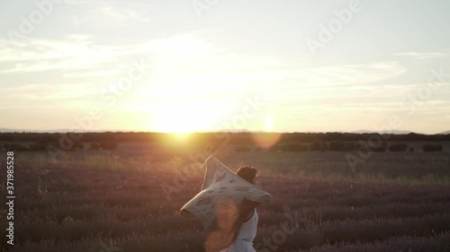 Woman spinning with her scarf among lavender fields