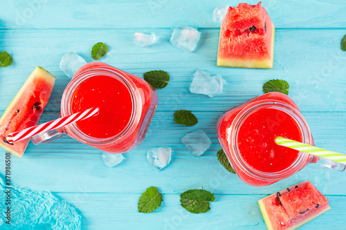 Fresh delicious watermelon smoothie with ice on blue background