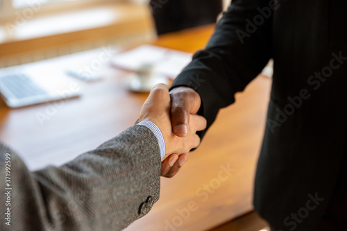 Close up of businessmen shaking hands in conference room, making a deal, successful agreement or cooperation. Concept of finance and business, contracts, partnership, community and teamwork.