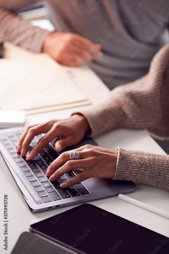 Fototapeta premium Close Up Of Businesswoman Working On Laptop At Desk Collaborating With Male Colleague