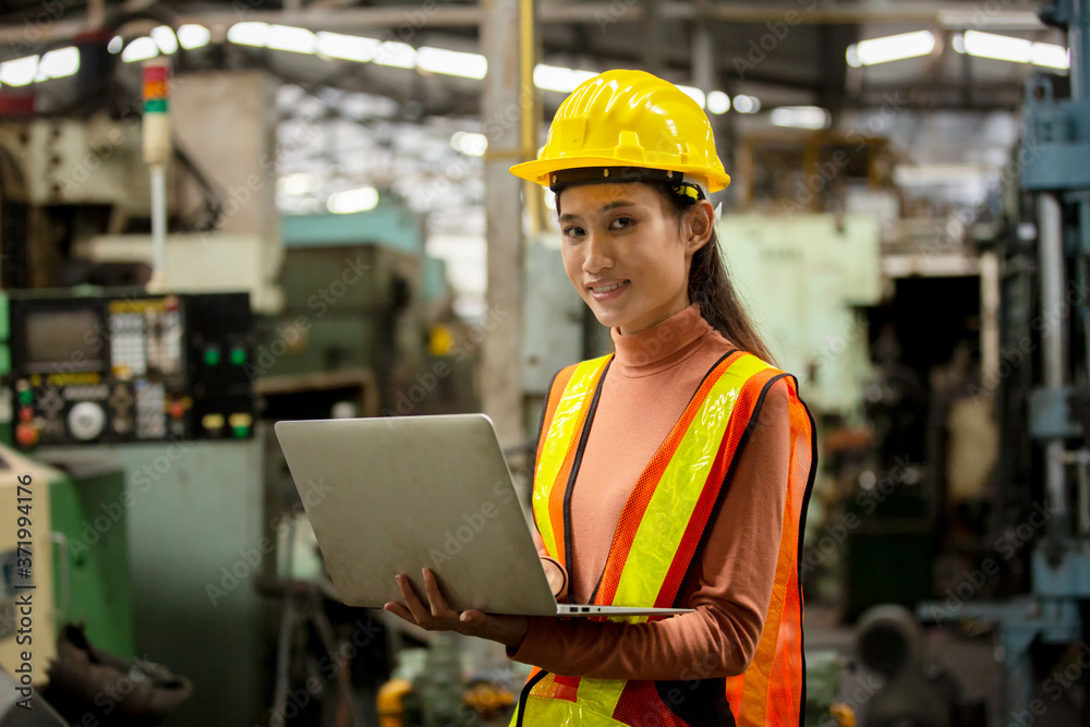 Portrait of female Engineer standing with confident against machine environment in factory