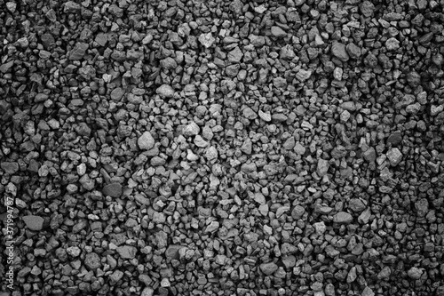 Gray small rocks ground texture. black small road stone background. gravel pebbles stone seamless texture. dark background of crushed granite gravel, close up. clumping clay