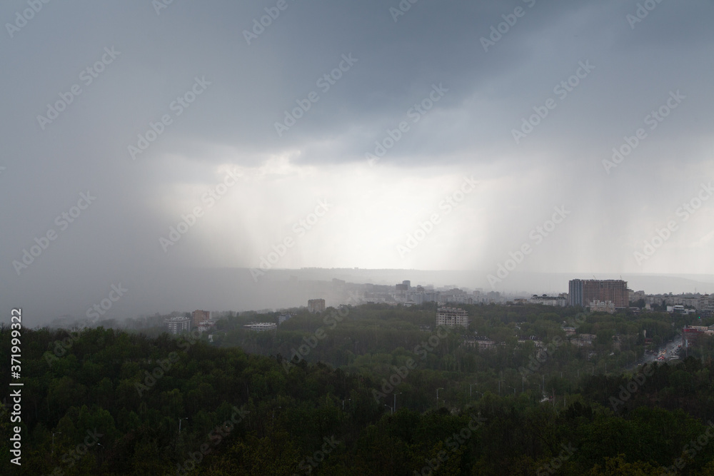 Dark cloud pouring rain over the city