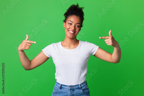 Happy young woman pointing fingers at herself