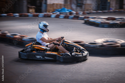 Male driving a kart on an indoor track
