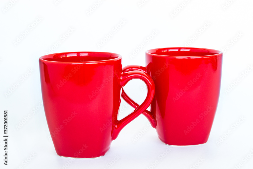 Two red mugs isolated on white background. Red cup. Close-up. Two red mugs isolated on white background. Red cup. Close-up.
