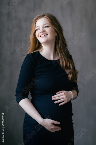 30 weeks pregnant pretty woman wearing a black bodycon dress. Planning pregnancy, preparing for childbirth