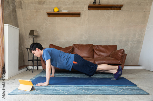 Man exercising at home in front of laptop