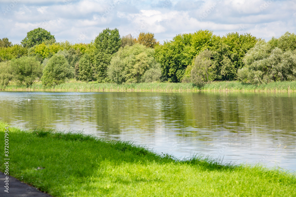 Shallow narrow river and green summer coast at daytime Shallow narrow river and green summer coast at daytime