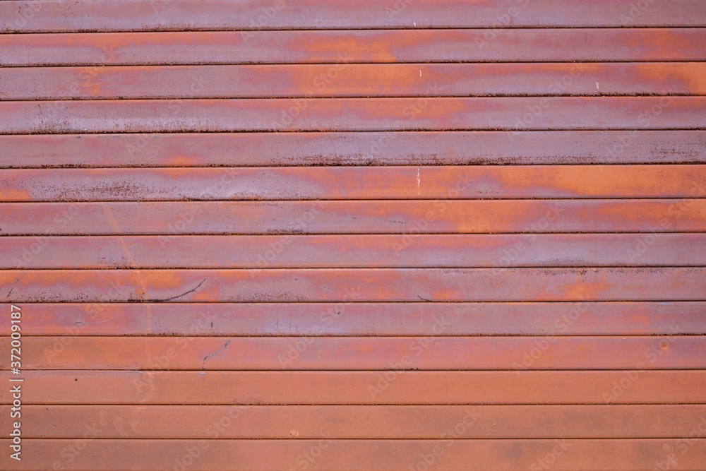 The wall is made of old rusty metal. The wall is made of old rusty metal.