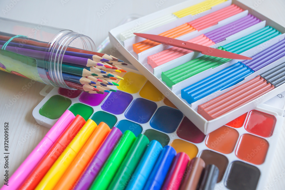 Fototapeta premium Bright beautiful colored pencils, felt-tip pens, watercolors, plasticine, everything for children's creativity.