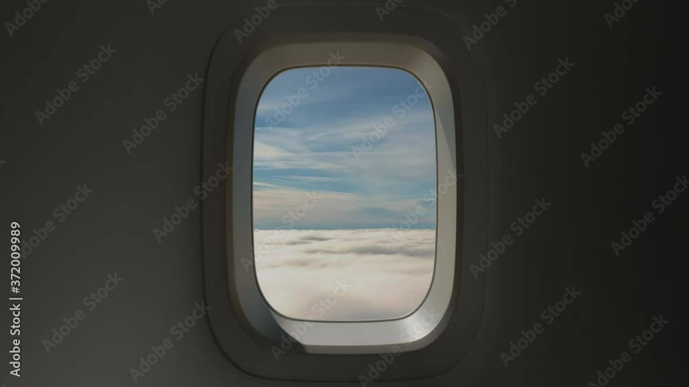 Airplane Window View Above the Clouds at Sunset Airplane Window View Above the Clouds at Sunset