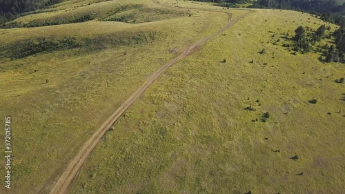 Aerial footage of a dirt road in the mountains