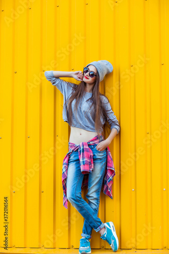 Beautiful Trendy teen Girl over Yellow Wall