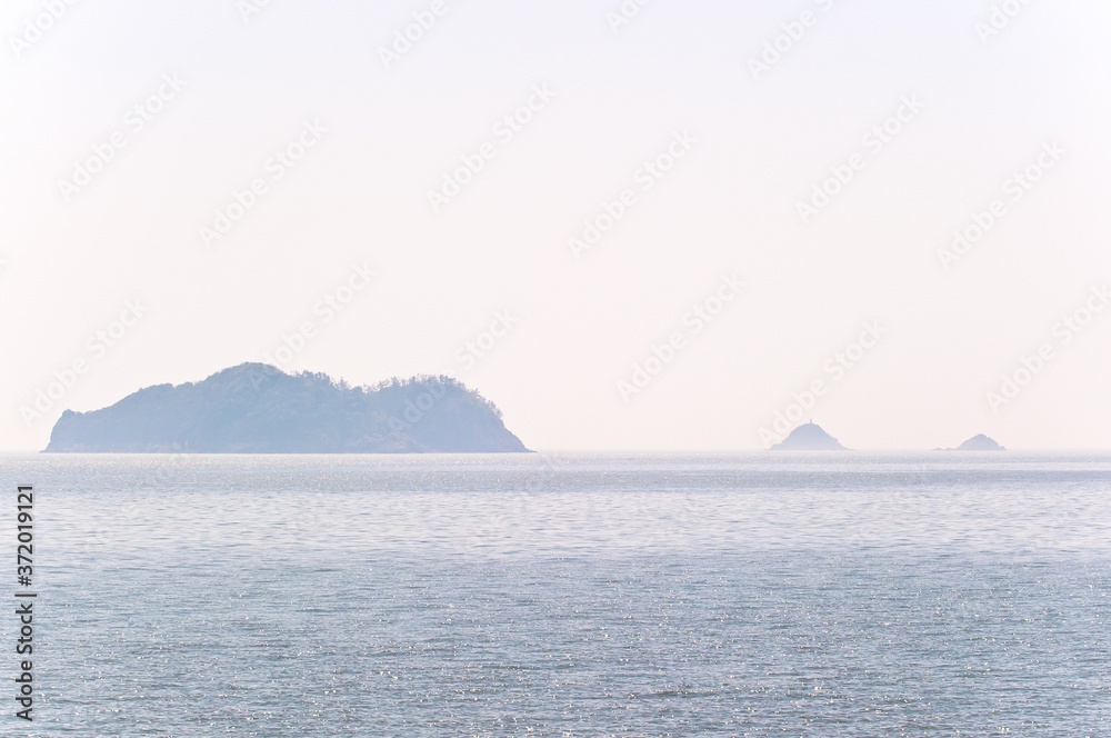 Misty island,mysterious seascape in light fog. Misty island,mysterious seascape in light fog.