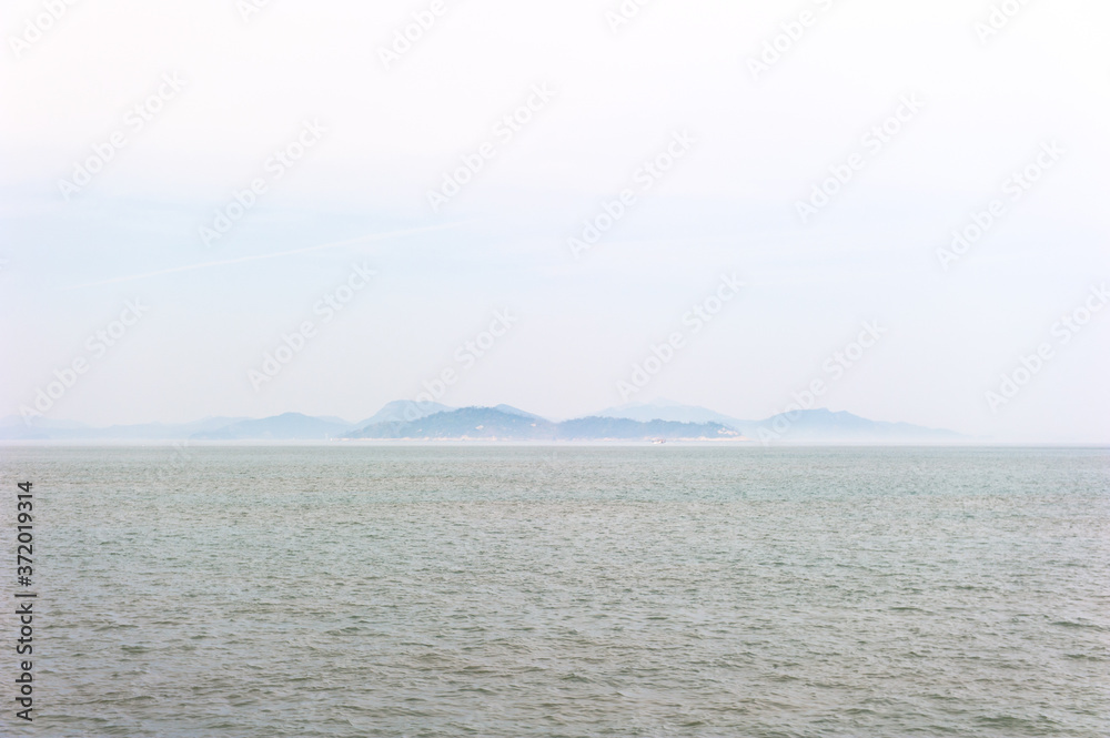 Misty island,mysterious seascape in light fog.