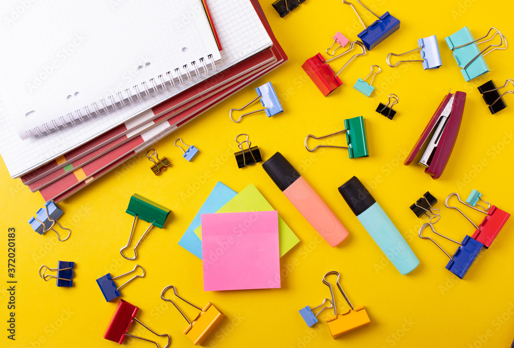 different stationary items on yellow as educational or office desk concept different stationary items on yellow as educational or office desk concept
