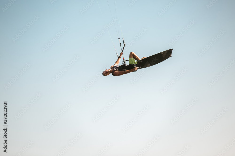 Fototapeta premium Kitesurfing Kiteboarding action photos man among waves quickly goes