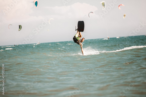 Kitesurfing. Man rides on kite on waves