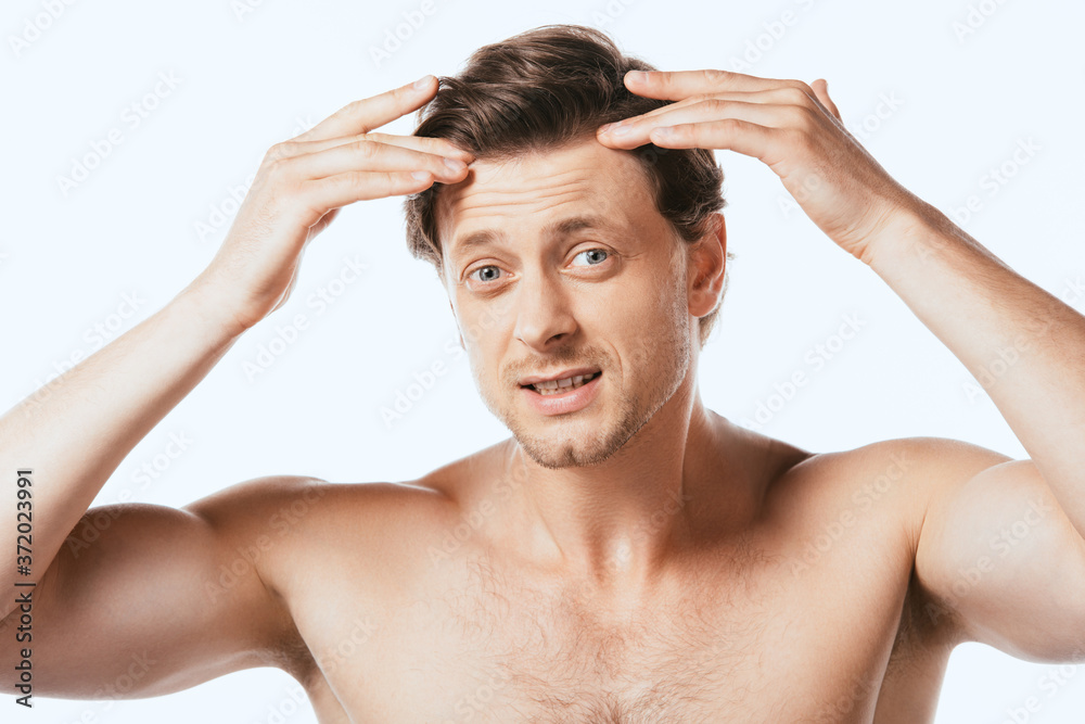 Confused shirtless man touching hair isolated on white Confused shirtless man touching hair isolated on white