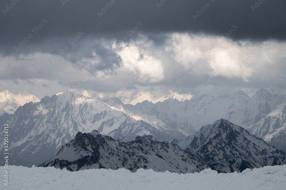 Evening high mountain scenery snow-covered rocky steep mountains of the main mountain range of the northern Caucasus