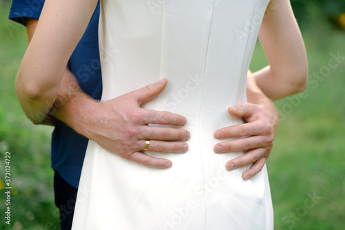 male hands hugging a woman's waist, close-up