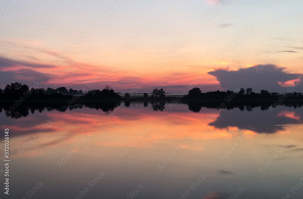 Sunset horizon mirrored in a lake