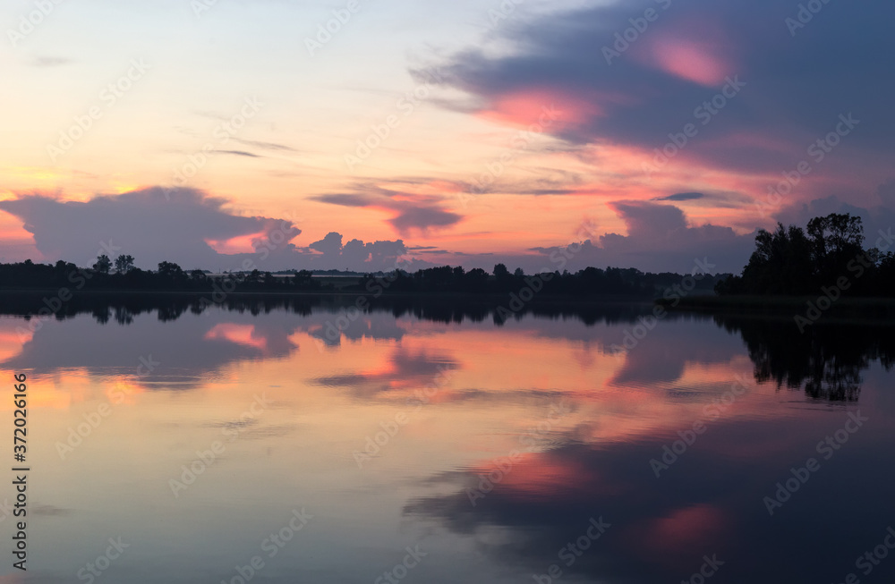 Sunset summer horizon mirrored in a lake