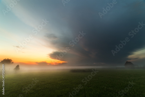 Sunset with stormy clouds and fog in the countryside