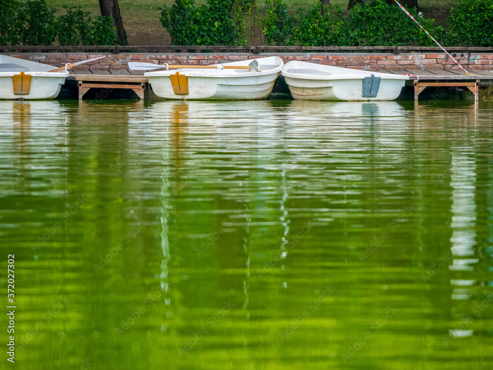 Obraz premium Boats parked by the wooden pier at the edge of the lake.