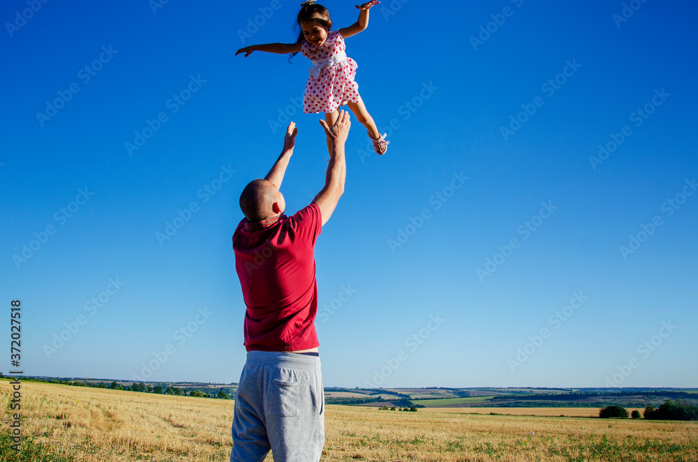 Parental custody. Happy daughter has fun playing with her father. Loving father and little daughter are playing. The father tosses the child. Happy child in the family Parental custody. Happy daughter has fun playing with her father. Loving father and little daughter are playing. The father tosses the child. Happy child in the family
