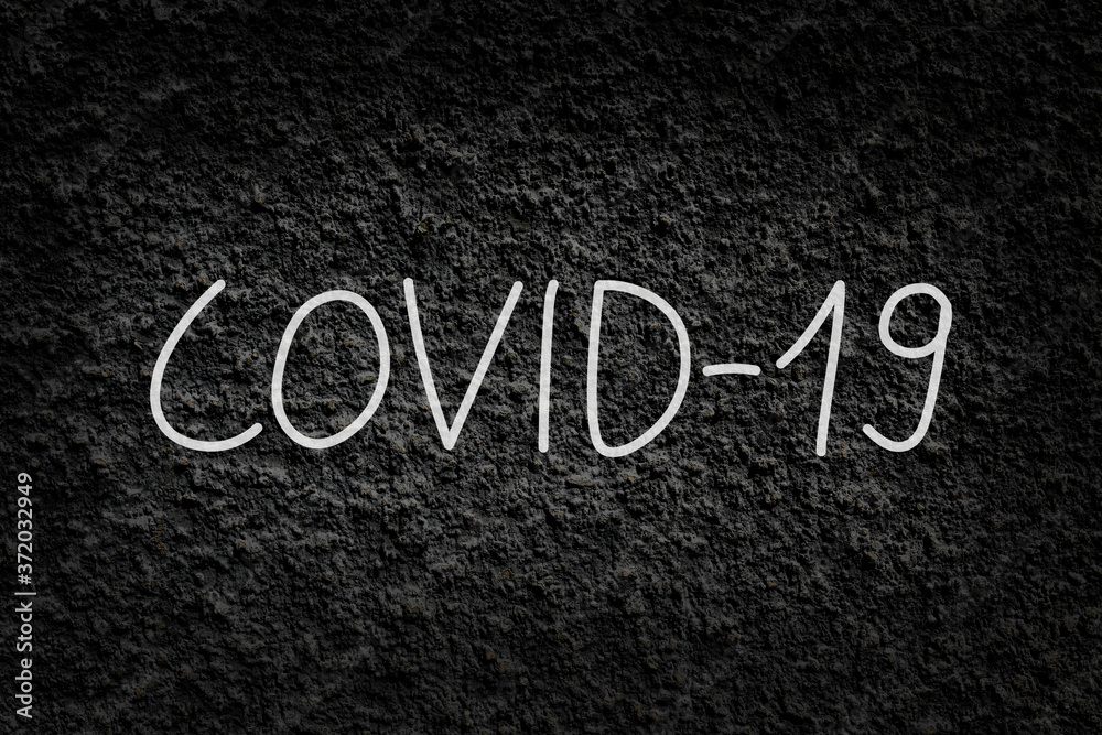 Fototapeta premium COVID-19; coronavirus disease written on black rough wall texture