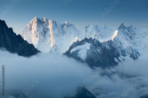 Grandes Jorasses and Mer de Glace behind the clouds. Winter season in France. First snow in Chamonix valley in Haute Savoie. Popular climbing attraction. Europe Alps
summits  photo