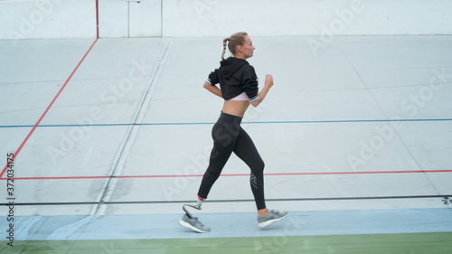 Disabled female runner starting to run on track. Jogger exercising at stadium © stockbusters