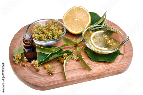 Fresh healthy linden flowers, lemon and tea with essential oil on a white background
