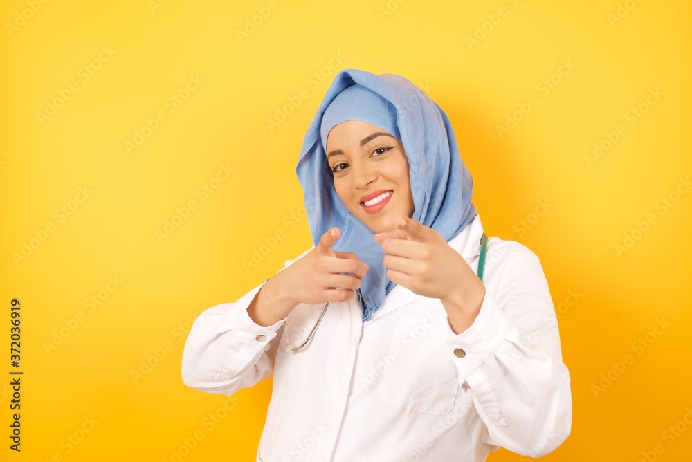 Φωτογραφία Young arab doctor woman wearing medical uniform pointing fingers to camera with happy and funny face