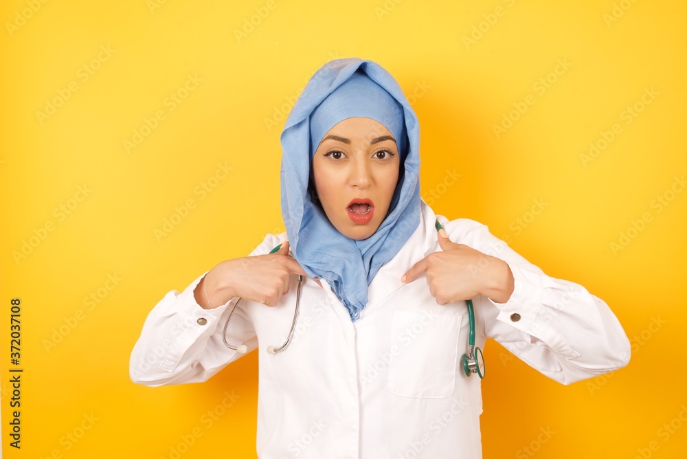 Φωτογραφία Photo of embarrassed Young arab doctor woman wearing medical uniform standing ov