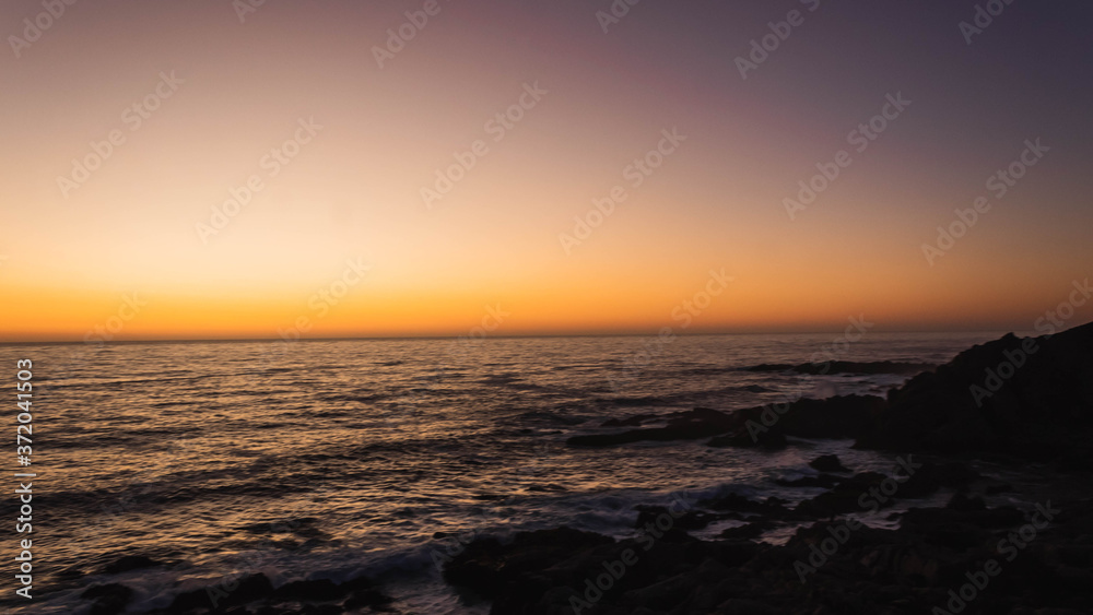 Hermoso atardecer en el borde costero de las playas de Punta Tralca en Chile.Puesta de sol en el océano.Cielo despejado con hermosos tonos anaranjados y violeta.