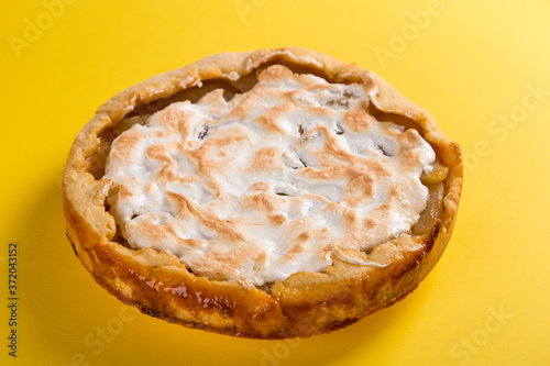 Pear pie on a blue napkin on a yellow background, the concept of homemade delicious pastries. Copy space.