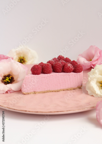 Raspberry cheesecake with berries and fresh flowers on pink plate food photo, sweet cake food photo art, kitchen, menu and restaurant photoshoot