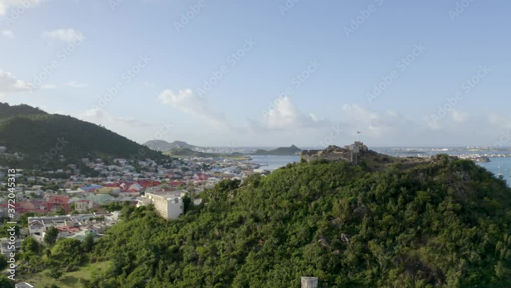 Aerial drone shot rising above Fort St. Louis in Marigot, Saint Martin in the Caribbean with the town, harbour and mountains in the background. Aerial drone shot rising above Fort St. Louis in Marigot, Saint Martin in the Caribbean with the town, harbour and mountains in the background.