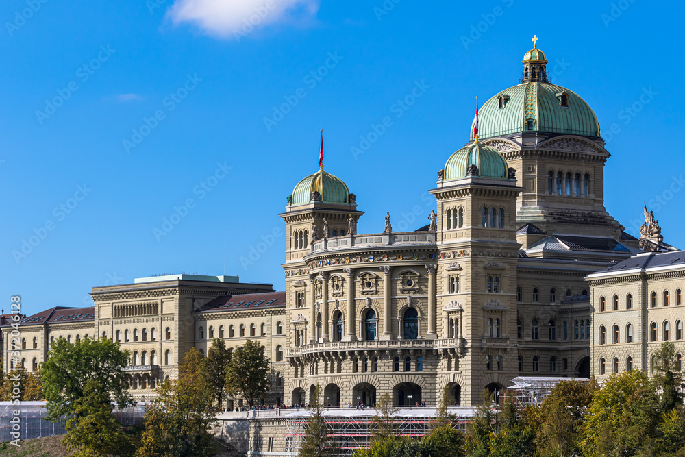 View of Federal Palace of Switzerland (Parliament Building) from south in old town of Swiss capital city Bern on sunny autumn day with blue sky and cloud, Switzerland