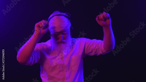 An albino grandpa dancing while wearing new earphones, isolated on a unique background.