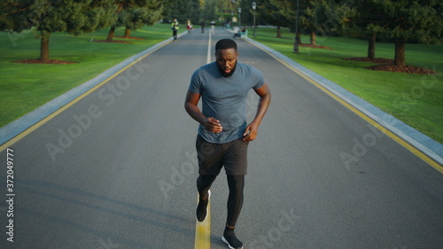 Jogger starting to run in park. Concentrated sportsman jogging outdoors