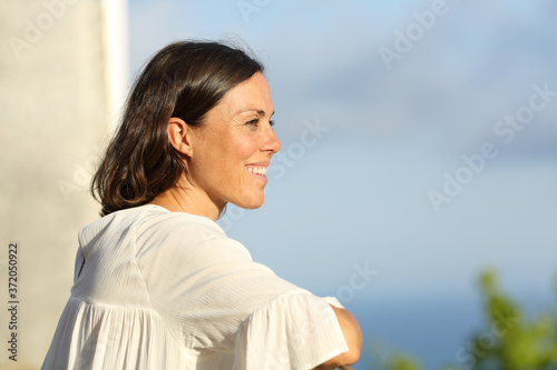 Mid aged woman contemplating from a balcony photo