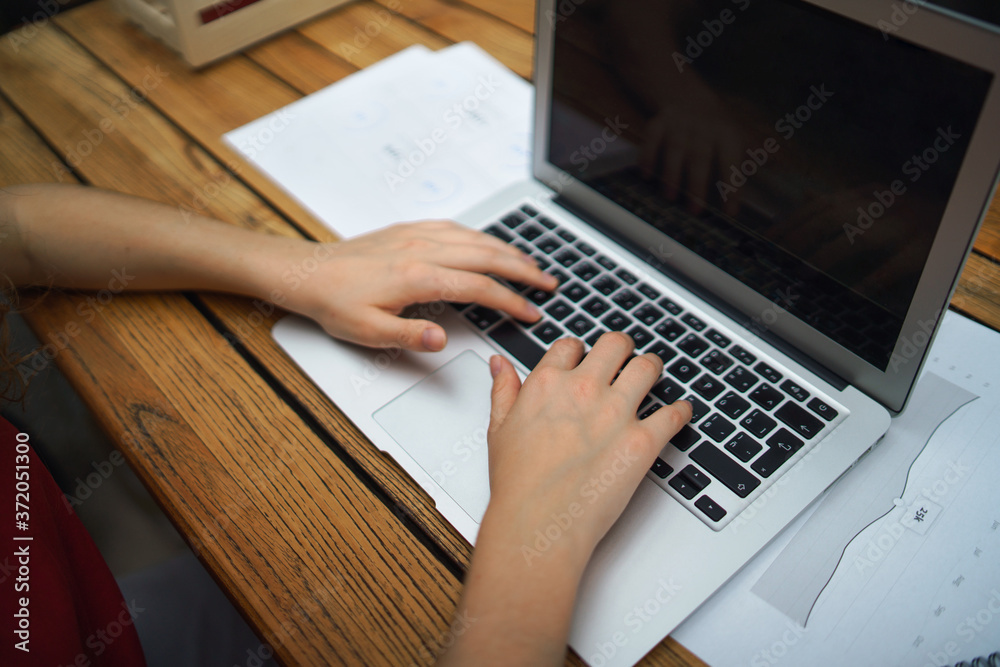 Fototapeta premium Unrecognizable woman with laptop sitting indoors in office, working.