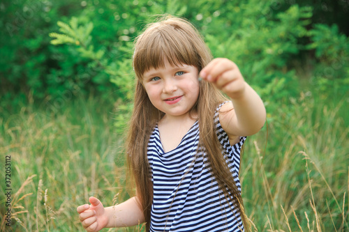 Little girl holding a butterfly in her hand, sharpness on her face